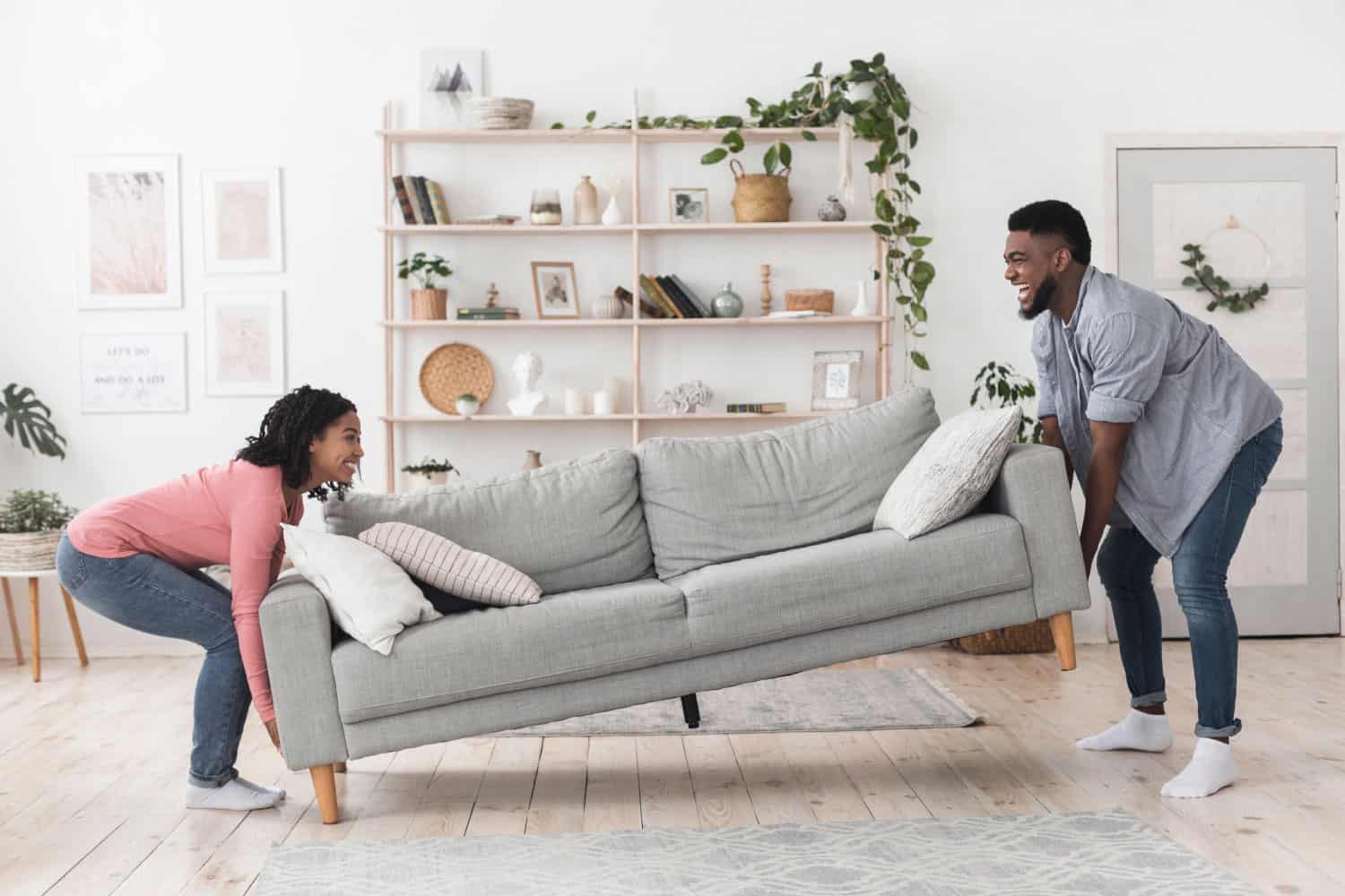 Happy couple moving a couch into a new apartment after a furniture donation pick up
