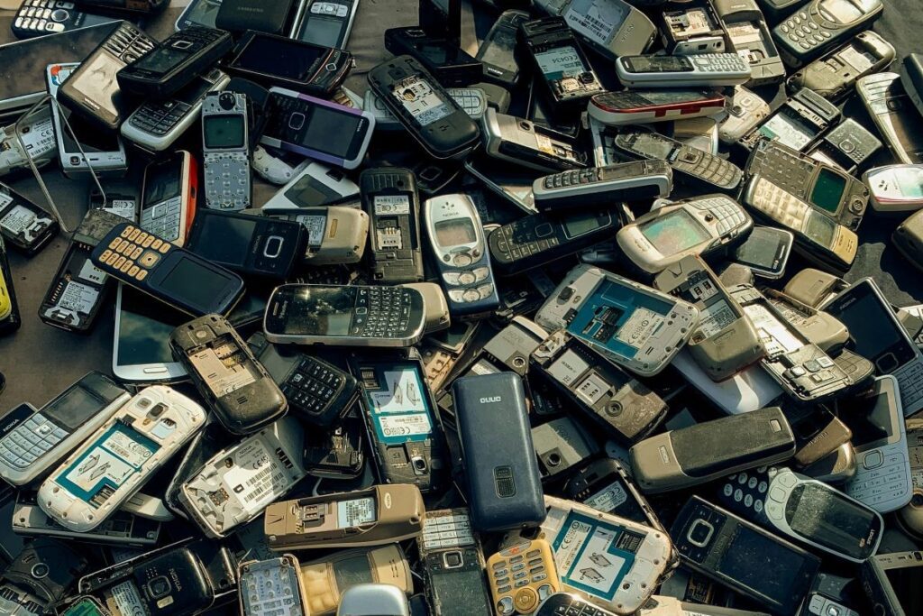 Pile of outdated cellphones waiting to be recycled to promote zero-waste living.