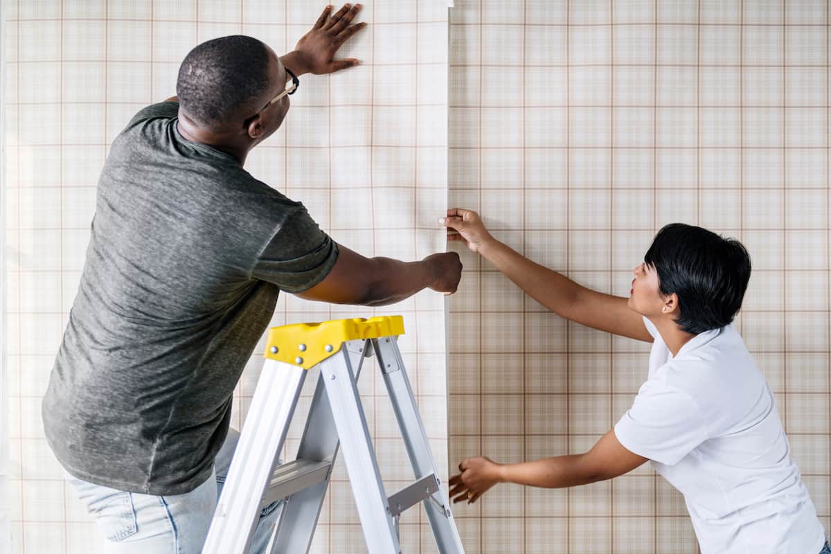 couple putting up wallpaper