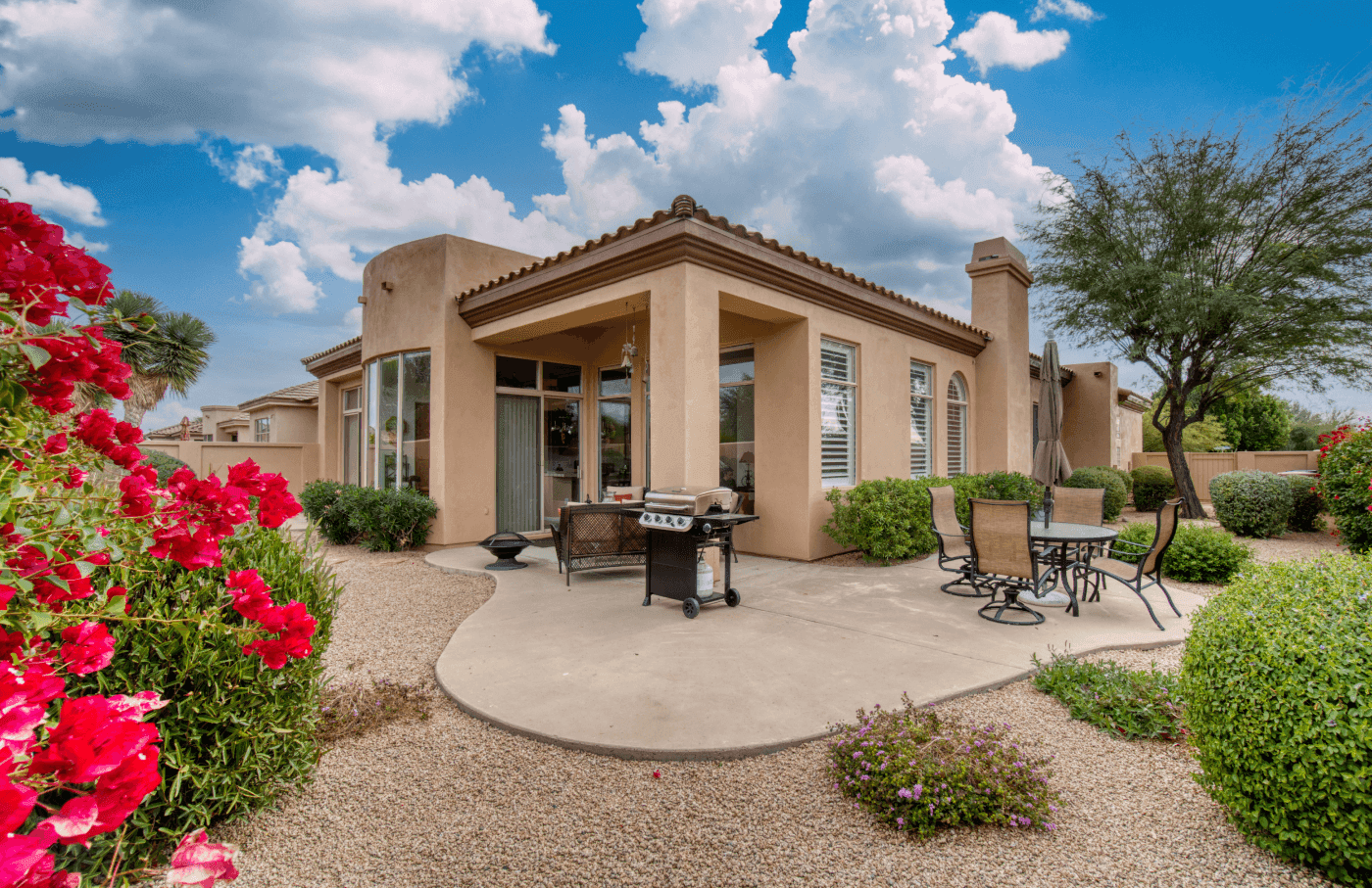 Exterior of home including patio and gardens.